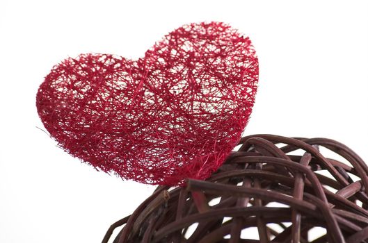 Wicker ball with a red heart made of artificial fiber