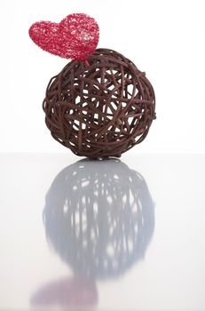 Wicker ball with a red heart made of artificial fiber