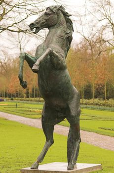 Statue of a horse standing on it's back legs in a park