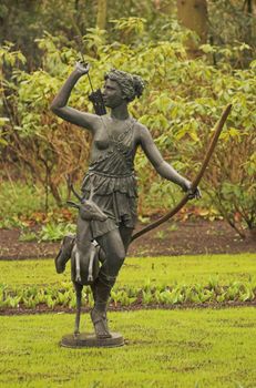 Statue of greek goddes Diana made of brass standing in a park