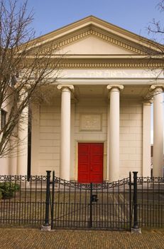 Old synagogue in greek (ionic) style behind a closed metal gate