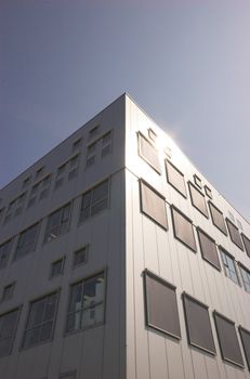 Modern office building shot from below, brightly lit by summer sun