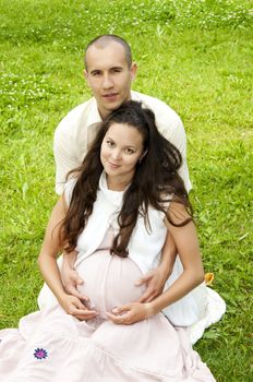 man and the woman lay together on cover,  smiling pregnant woman