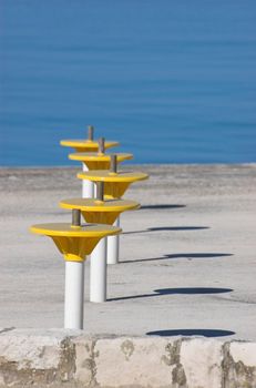 Umbrella holders on a terrace next to a sea