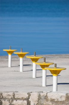 Umbrella holders on a terrace next to a sea