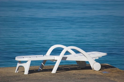 Plastic beach chair at the edge of a sea
