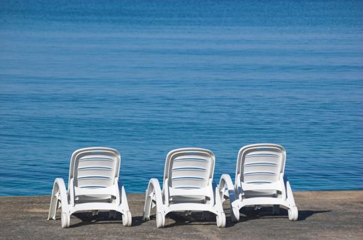 Plastic beach chair at the edge of a sea