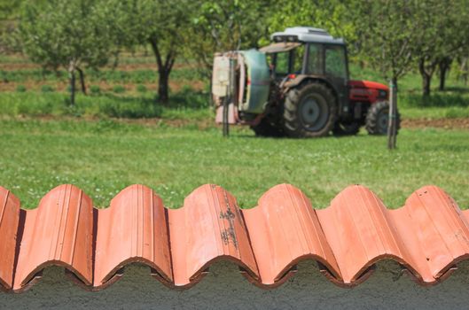 Agricultural tractor photographed from behind a garden wall