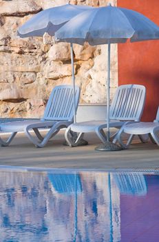 Plastic white chairs standing on a swimming pool terrace