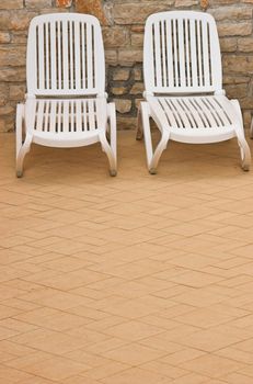 Plastic white chairs standing on a swimming pool terrace