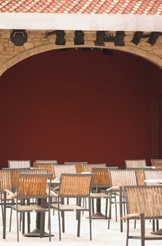 Cafe terrace filled with chairs next to a theatre scene