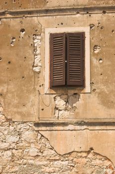 Old building facade in Croatia spotted with bullet holes