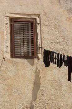 Washed clothes hanging on a rope from a window in Croatia