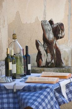 Bottles of wine and a menu on top of a terrace table