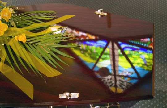 Stained Glass window reflection on a casket