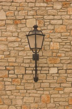 Electric lantern in old style hanging on a wall
