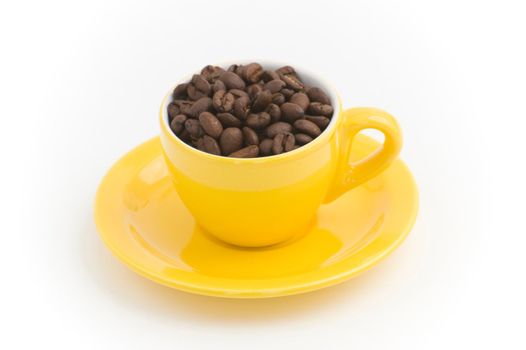 Yellow espresso cup filled with coffee beans