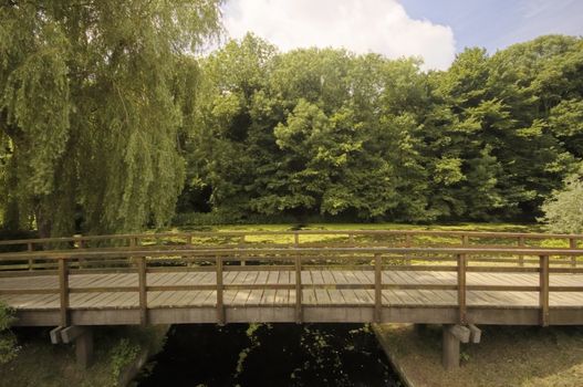 Wooden bridge in a park next to a dutch canal