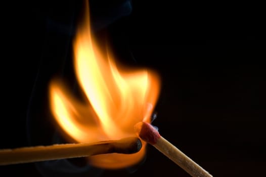 two matches on fire isolated on black background