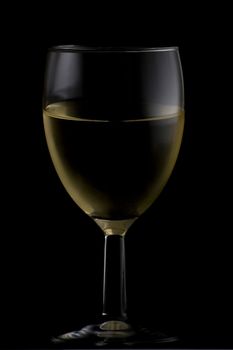 Short wine glass isolated on black filled with white wine