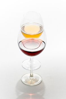 Two tall glasses isolated on white filled with red and white wine