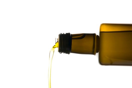 Olive oil being poured from a bottle isolated on white