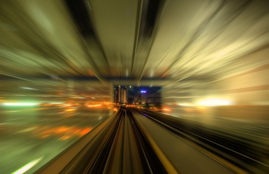 Speedy trains passing train station. Focus on the rail road. 

