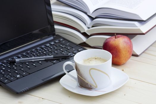 cup of coffee, laptop and books