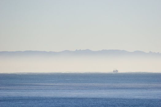 Mist over the ocean with a fishing boat