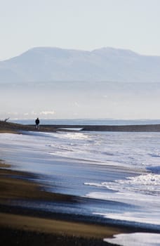 A walker strolls along Haumoana Beach in Autumn