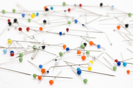 Handful of steel pins with colorful heads isolated on white