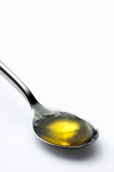 Teaspoon of olive oil isolated on white