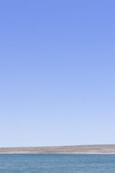 Water, shingle and sky on a hot day. Haumoana lagoon, Hawke's bay, New Zealand