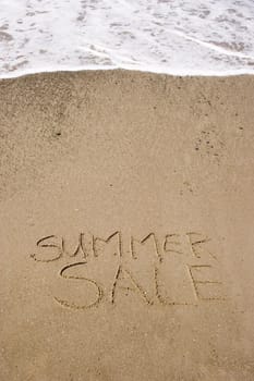 A summer sale written in the sand