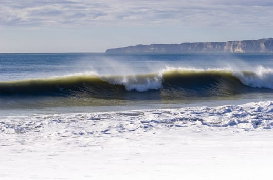 Waves breaking with Cape Kidanppers in Background. Hawke's Bay, New Zealand