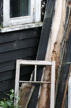 discarded timber leans against an old bach on Rangitoto Island, Hauraki Gulf, New Zealand