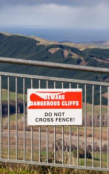 A sign on a fence on Te Mata Peak looking out toward the East Coast of Hawke's Bay, New Zealand