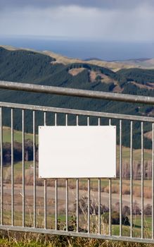 A blank sign on a fence on Te Mata Peak looking out toward the East Coast of Hawke's Bay, New Zealand