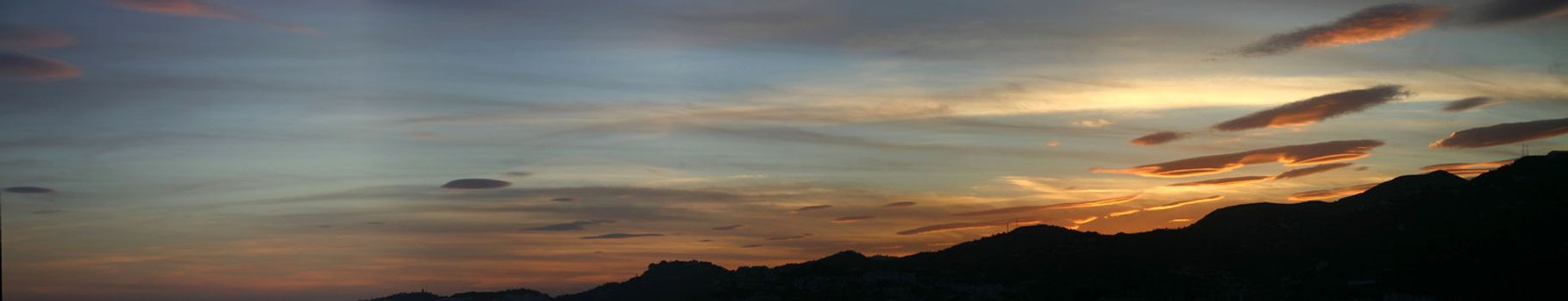 A fleet of lenticular clouds invading from the mountains at sunset