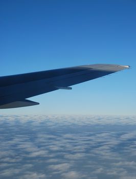 photo of a airplane wing and clouscape scene