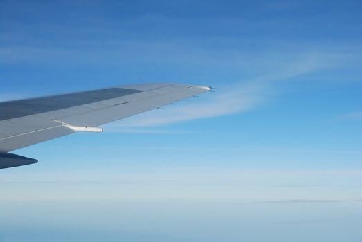 photo of a airplane wing and blue sky