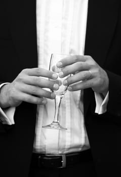Glass of champagne in a hand of the groom