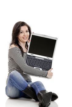 Young woman seated on the floor showing something on a laptop