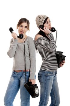 Two young women talking with old telephones - Isolated on white