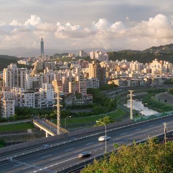 It is a cityscape photo of apartments and highway.