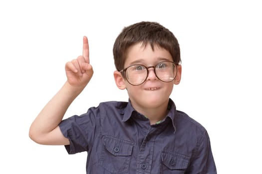 Little boy in round spectacles raising finger in funny attention gesture isolated