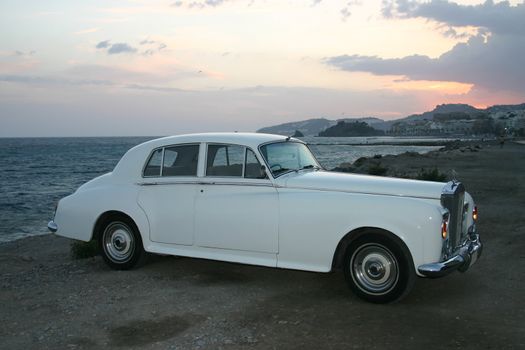 Side profile of a white luxury car from the 60's