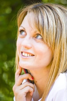 portrait of beautiful young blond woman talking on mobile phone