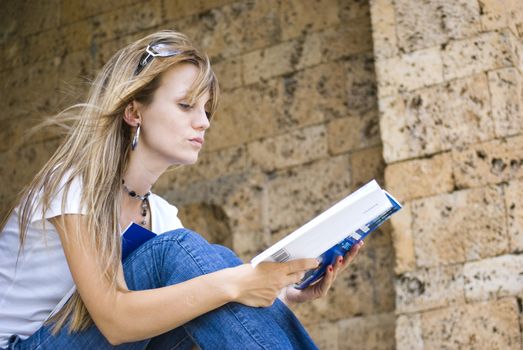 beautiful young woman reading book outdoor