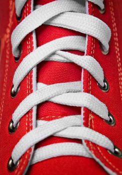 On red old-fashioned gym shoes a lacing close up
